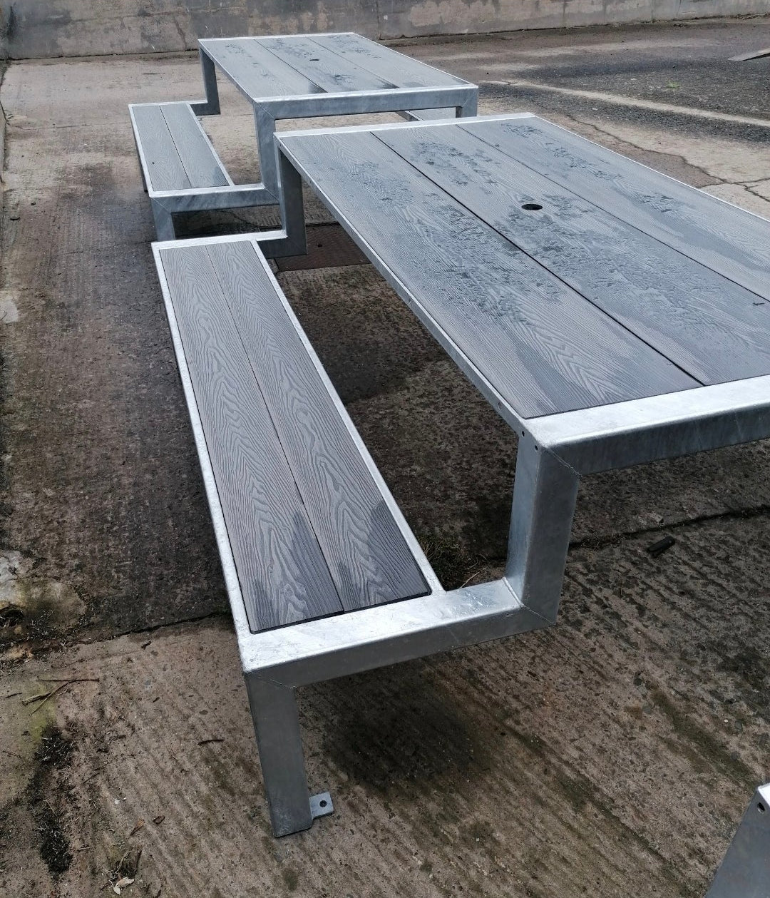 Outdoor metal picnic table and benches on a concrete surface made by Fire Pit Stop NI